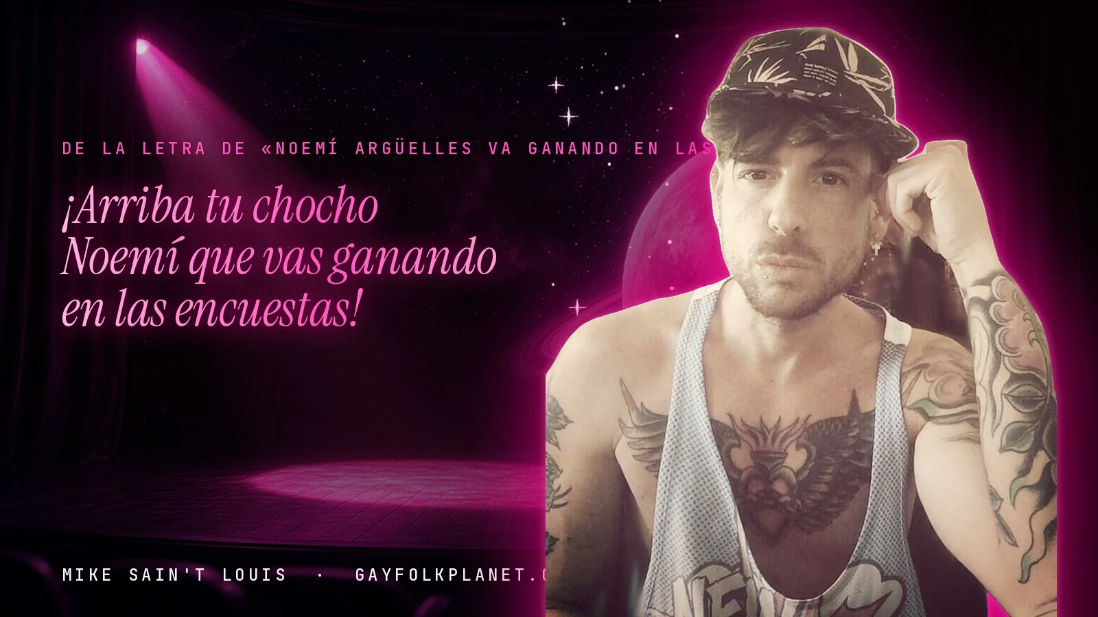 Mike Sain't Louis en un escenario con foco rosa y un planeta con anillos, con el verso «¡Arriba tu chocho Noemí que vas ganando en las encuestas!» de «Noemí Argüelles va ganando en las encuestas»