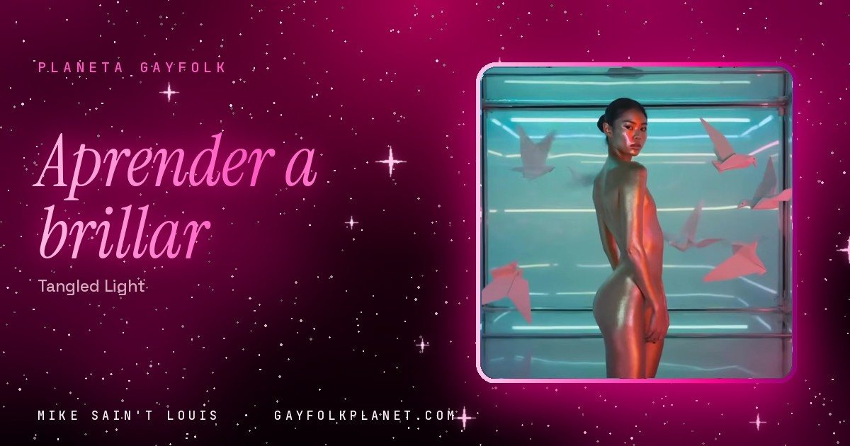 Fotograma del videoclip de «Tangled Light»: una figura de piel dorada dentro de una caja de cristal iluminada con neones rosas y azules, rodeada de grullas de papel