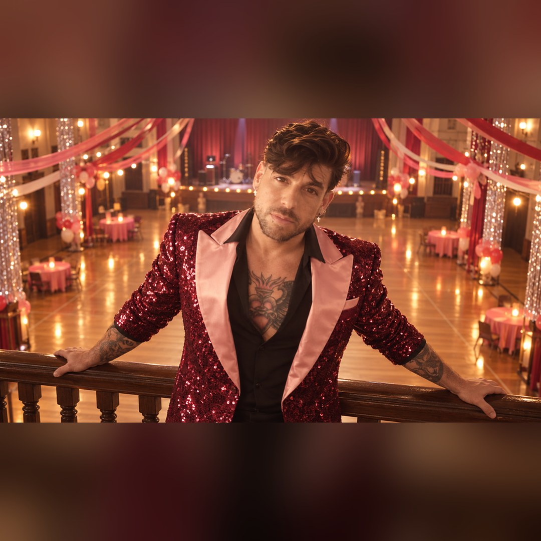 Mike Sain't Louis con chaqueta de lentejuelas granate y solapas rosas apoyado en la barandilla de un salón de baile — foto PLANETA GAYFOLK.