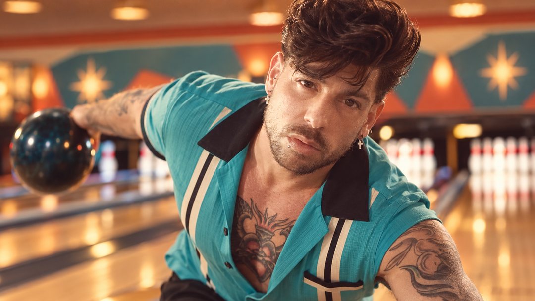 Mike Sain't Louis con camisa de bolos turquesa y negra lanzando una bola en una bolera de estilo cincuentero — retrato Tupé Grease PLANETA GAYFOLK.