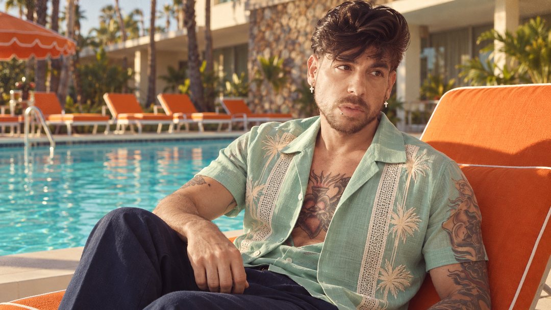 Mike Sain't Louis con camisa de bolos verde menta recostado en una tumbona junto a una piscina — foto retro PLANETA GAYFOLK.