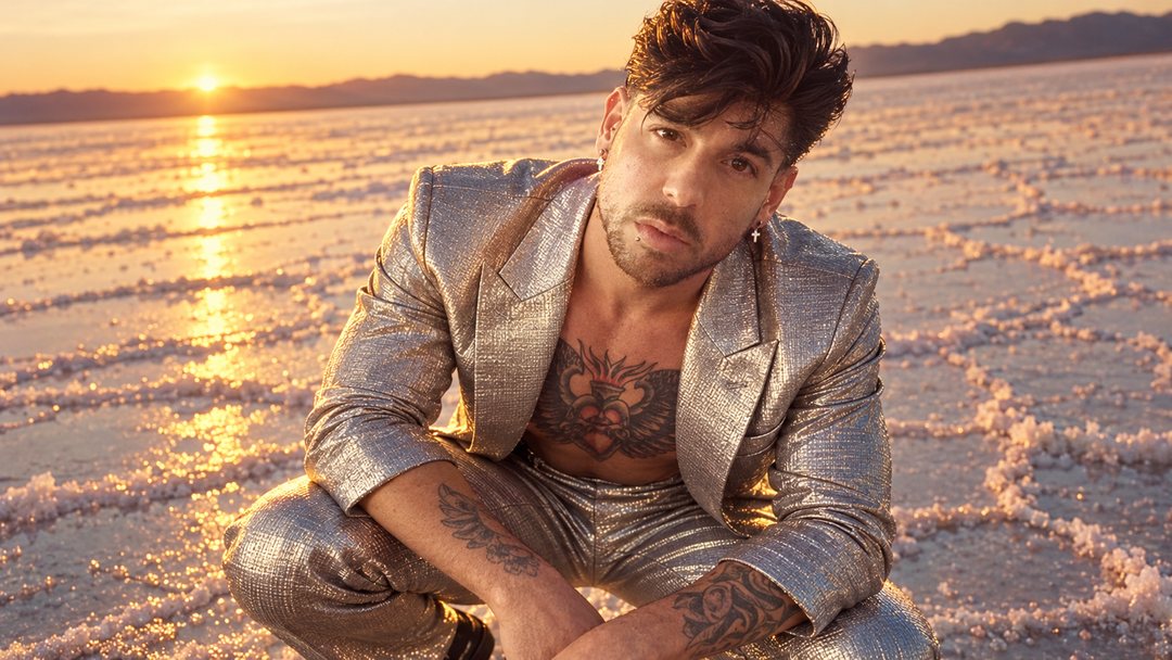 Mike Sain't Louis con traje plateado metalizado agachado sobre un salar al atardecer — retrato Tupé Grease PLANETA GAYFOLK.